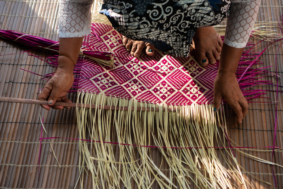 Women's School members showing traditional weaving to the Australian Ambassador